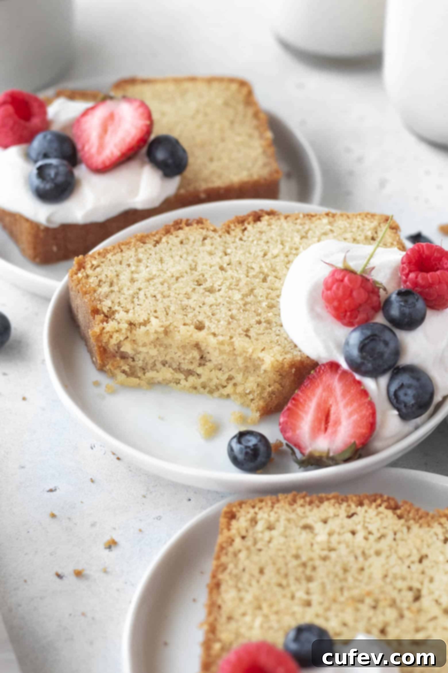 A beautiful slice of tender gluten-free pound cake on a white plate, ready to be enjoyed.