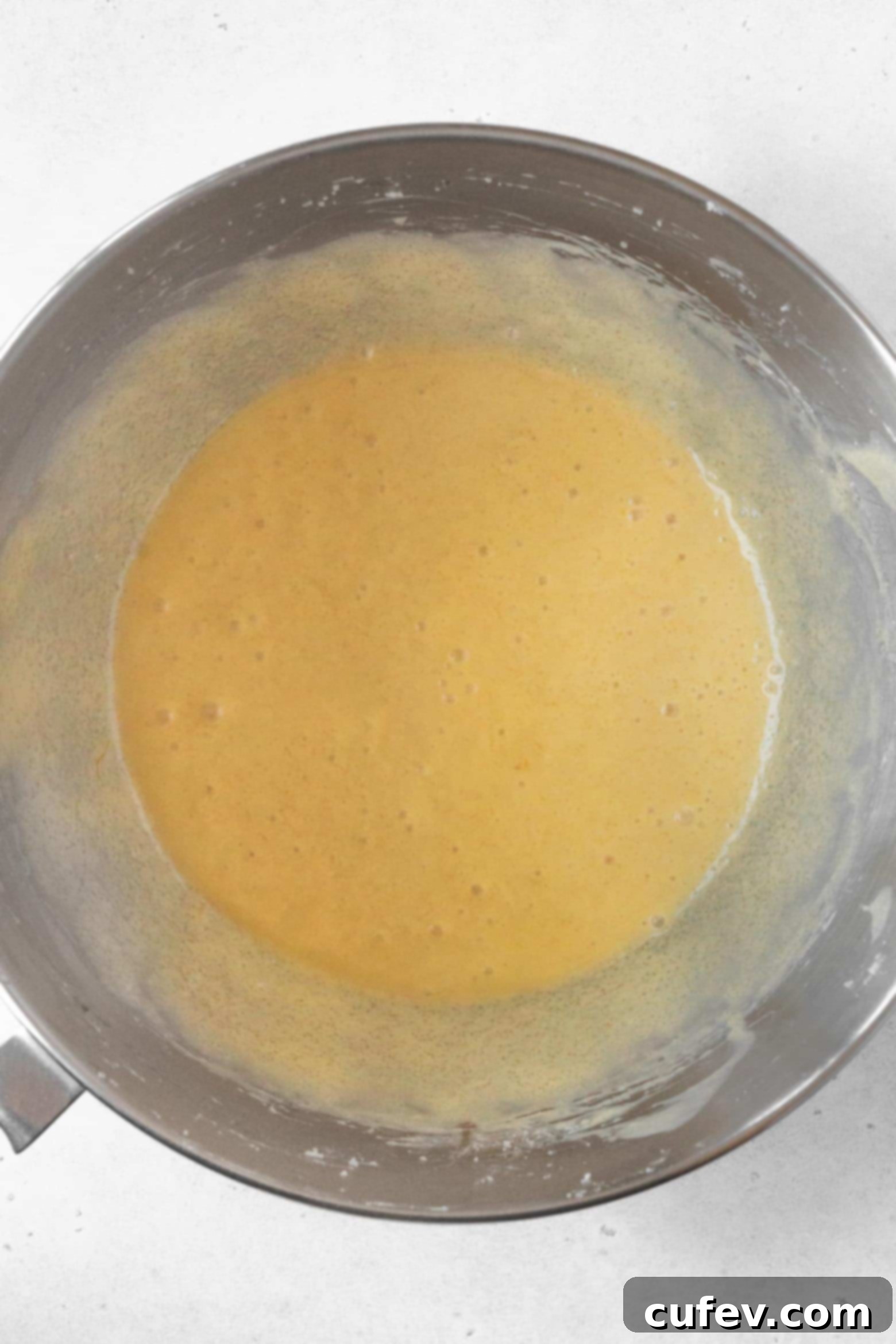 Smooth gluten-free pound cake batter in a stand mixer, ready for the next step.