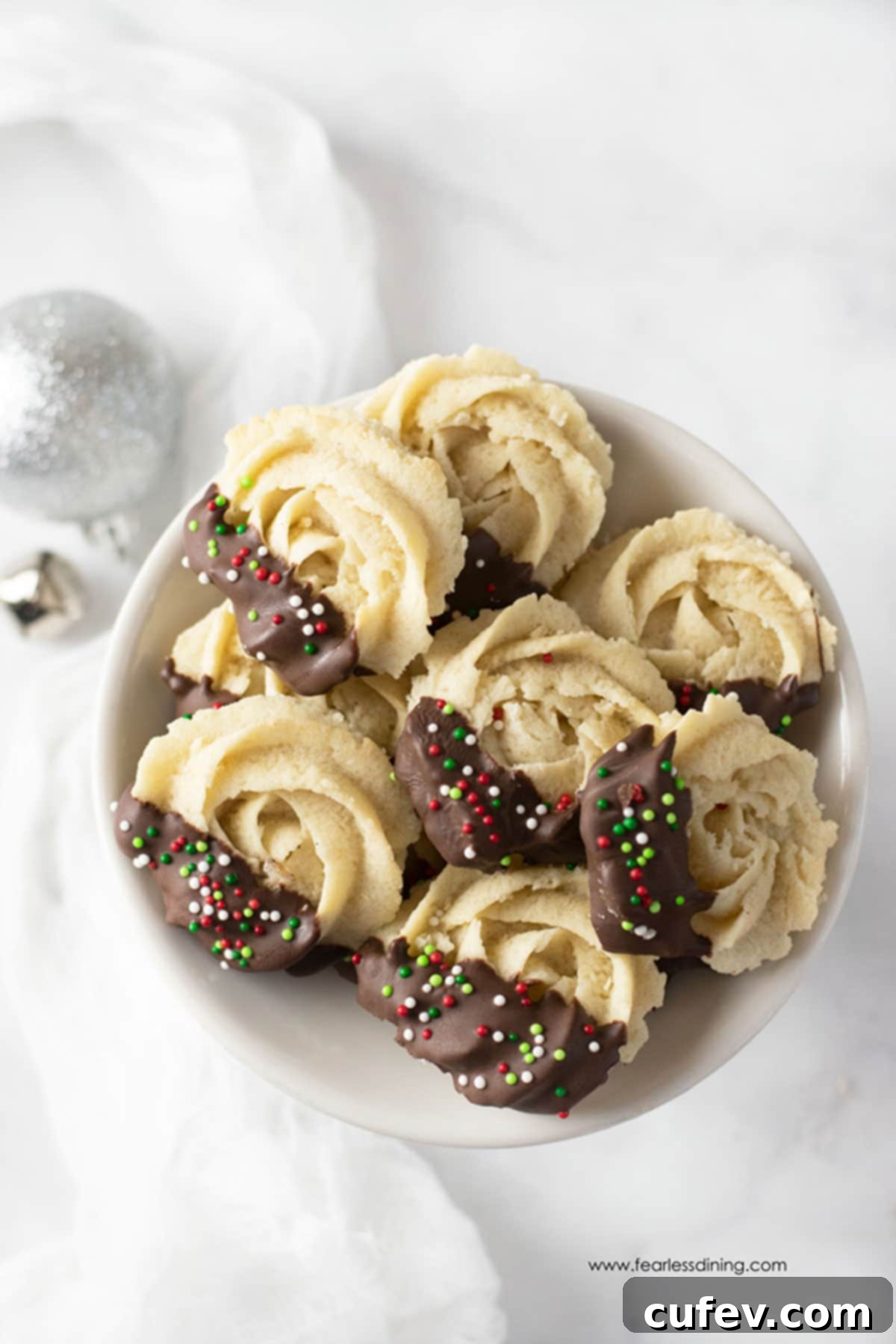 A plate of Danish butter cookies dipped in chocolate with some Christmas sprinkles.