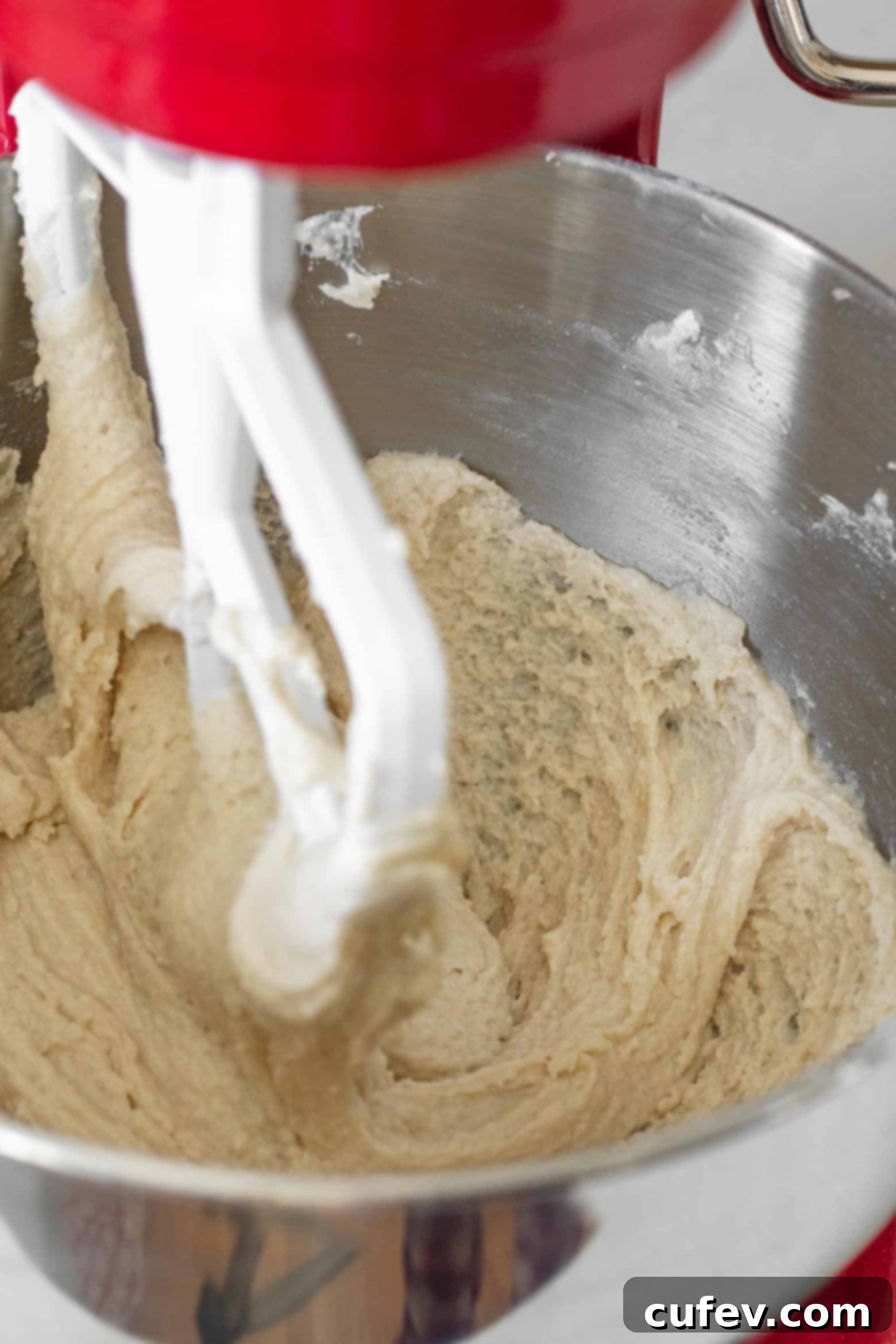 Gluten-free sugar cookie dough in the bowl of a stand mixer.