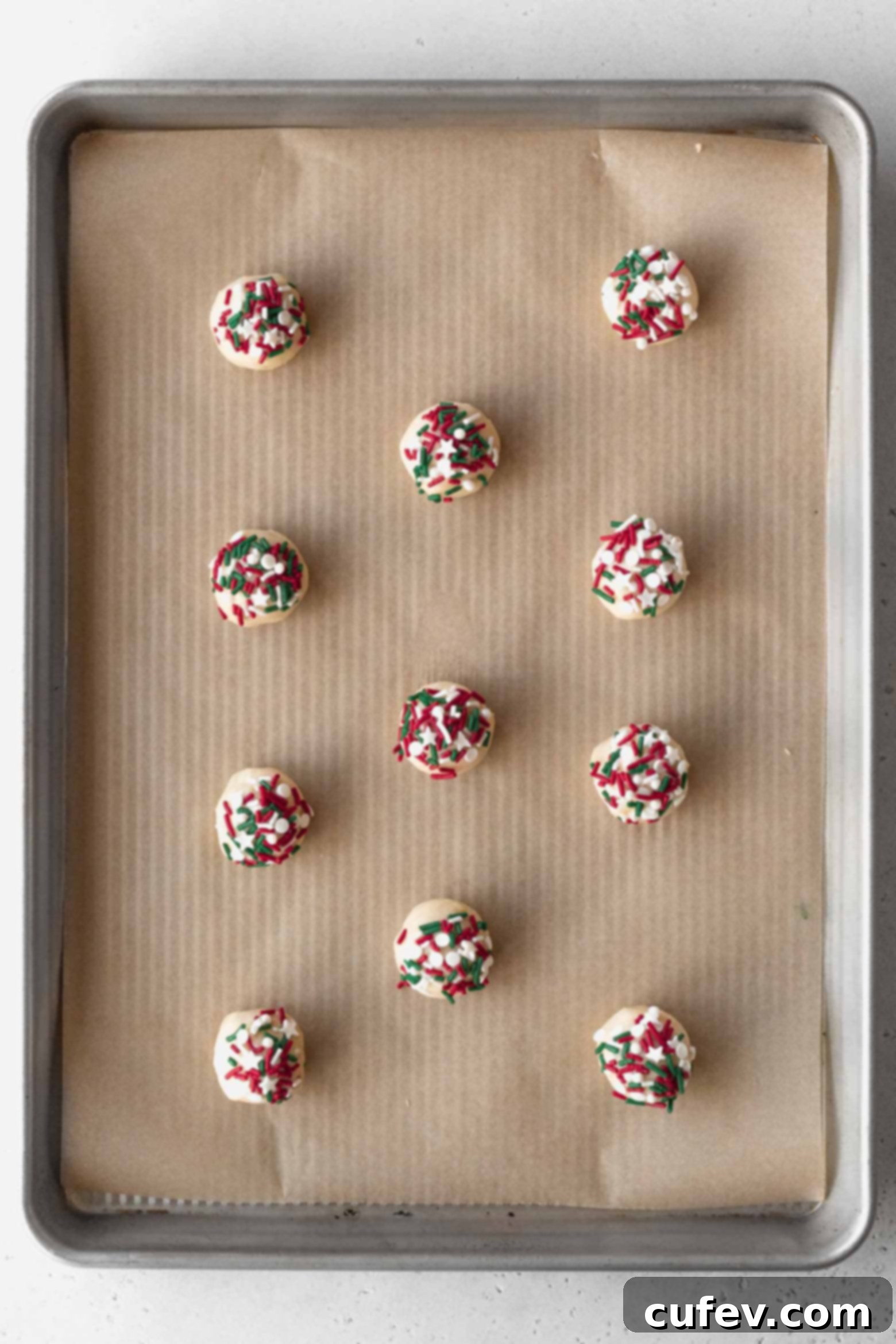 Put sprinkles on balls of cookie dough and place them on a baking sheet.