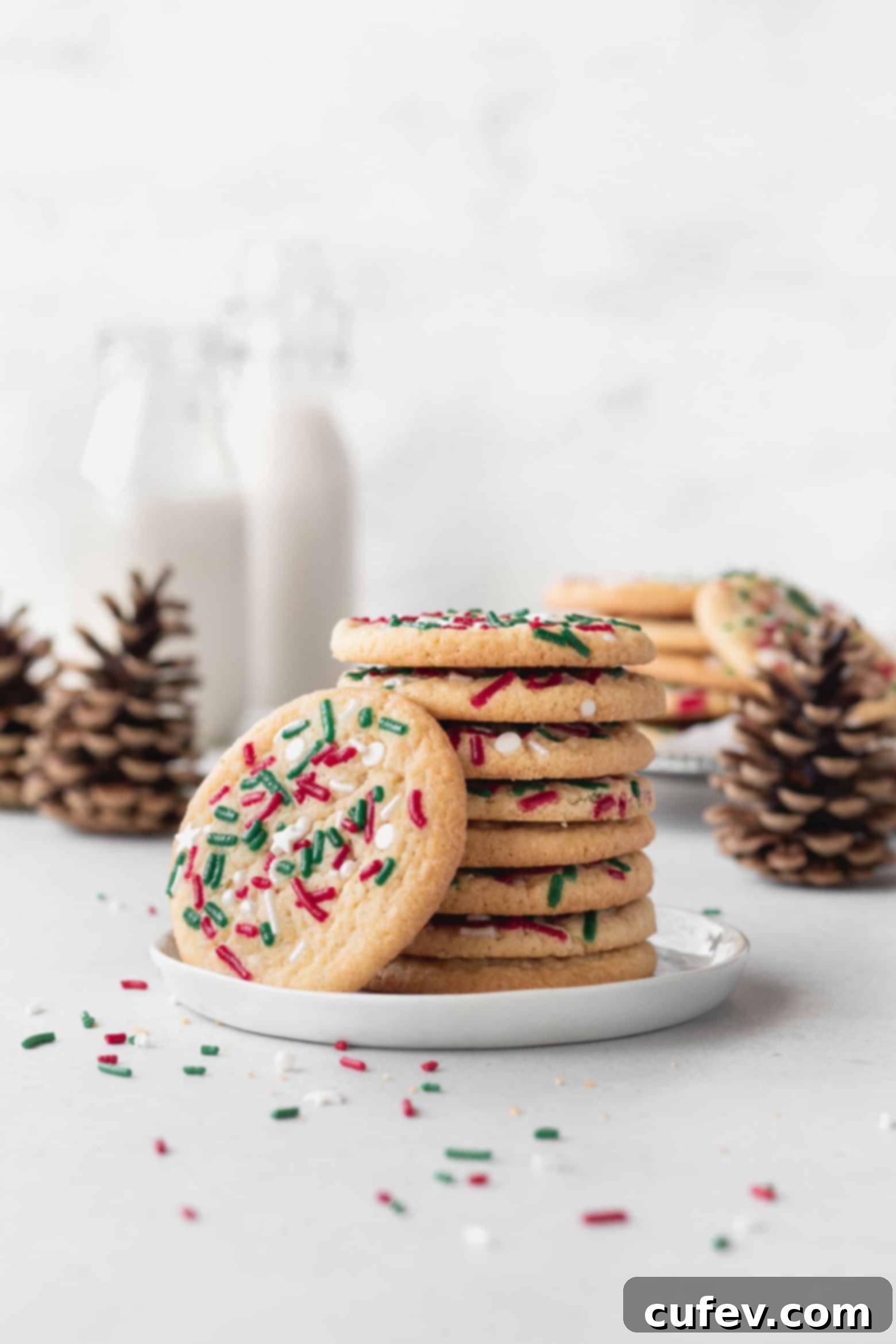 A stack of gluten free Christmas cookies on a white dessert plate.