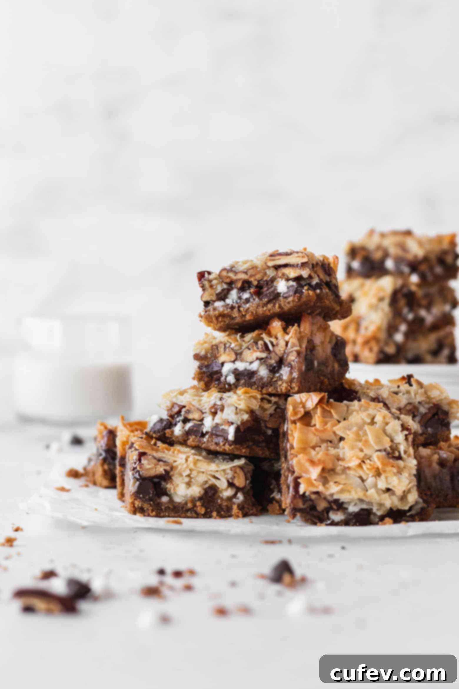 A stack of golden brown vegan magic bars on a white surface, ready to be enjoyed.
