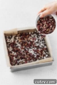 Adding a layer of chopped pecans over a layer of chocolate chips.