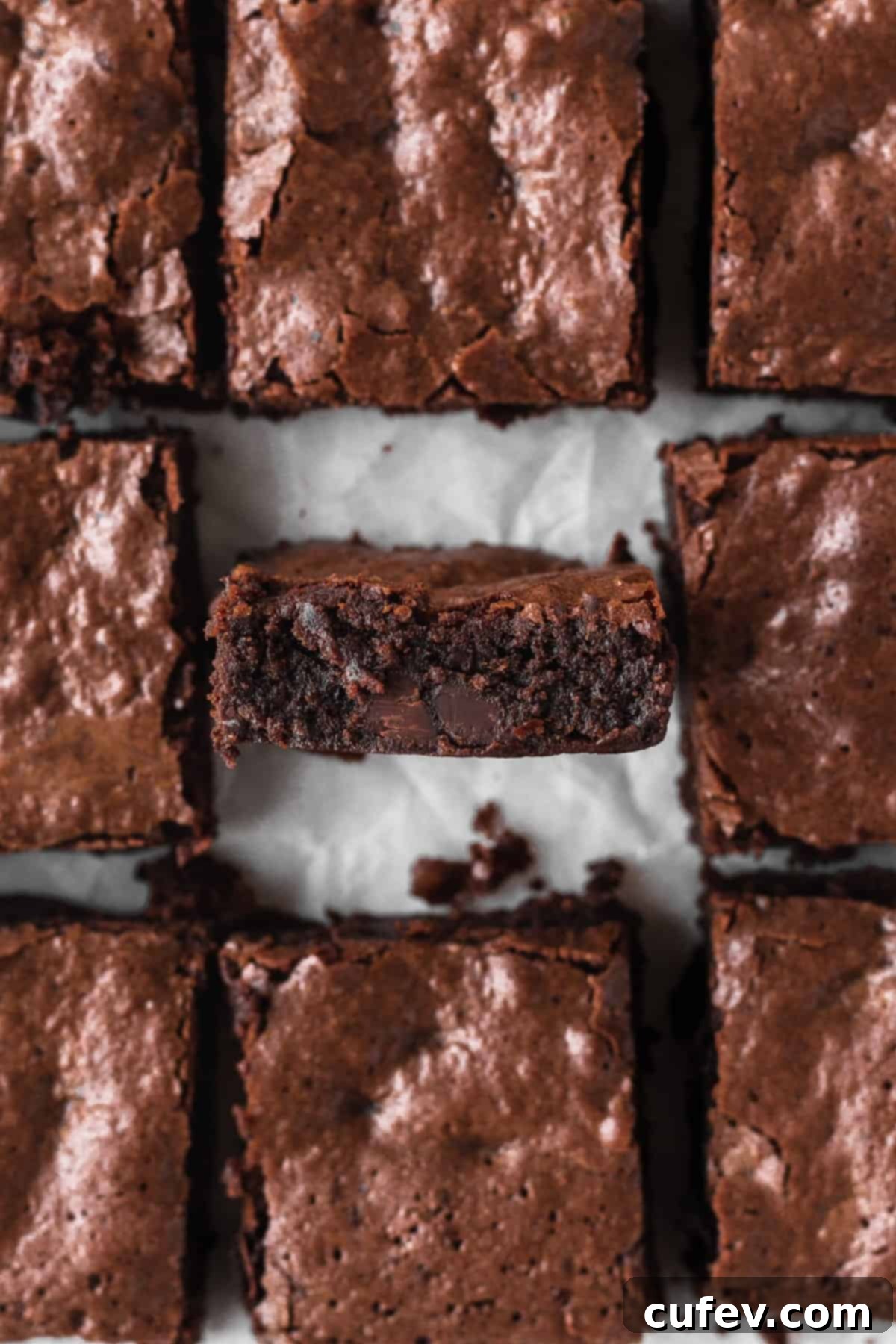 Gluten-free brownies cut into squares with the middle one turned onto its side edge to show the texture.