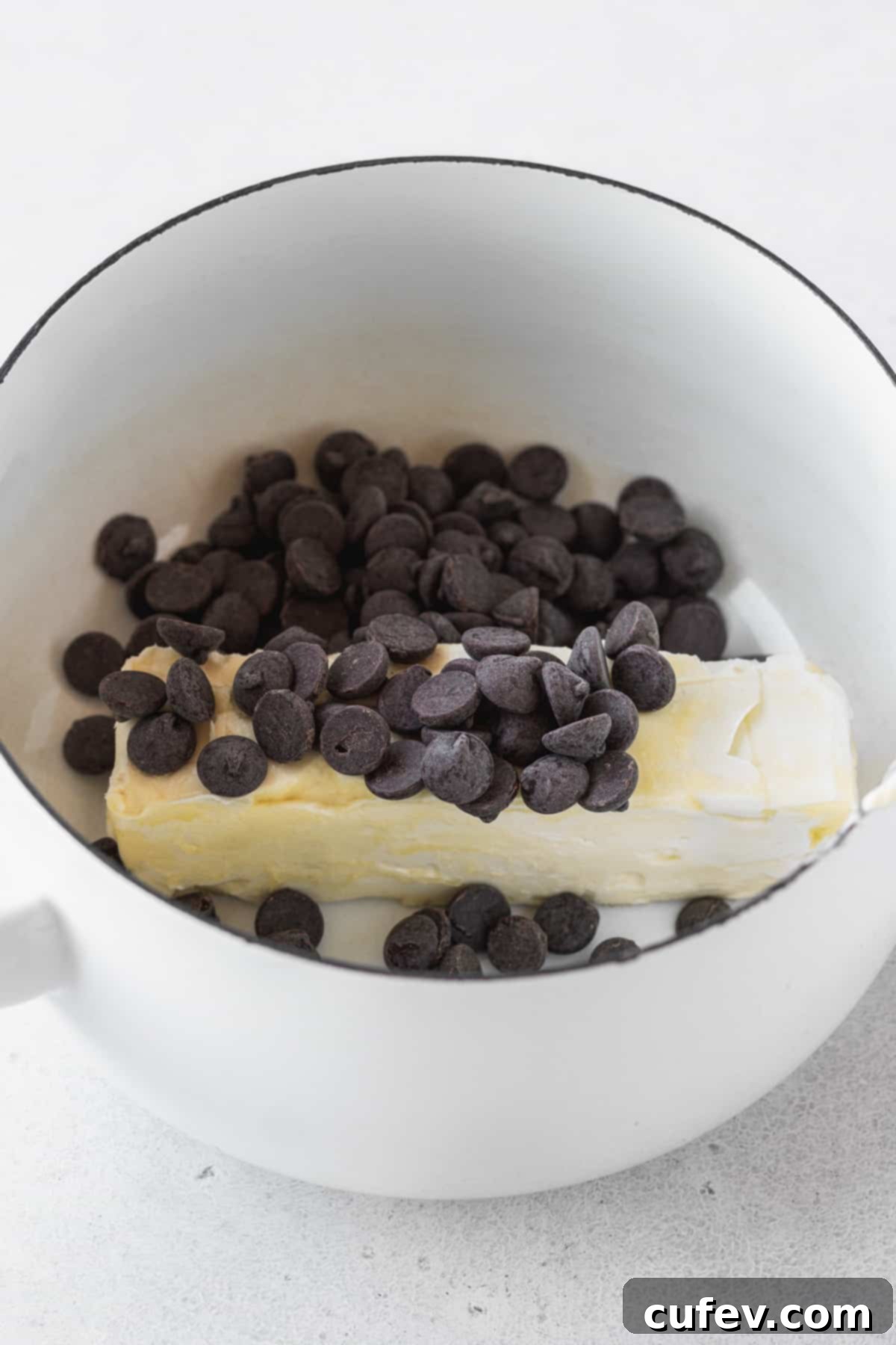 Butter & chocolate chips in a white enameled dutch oven.