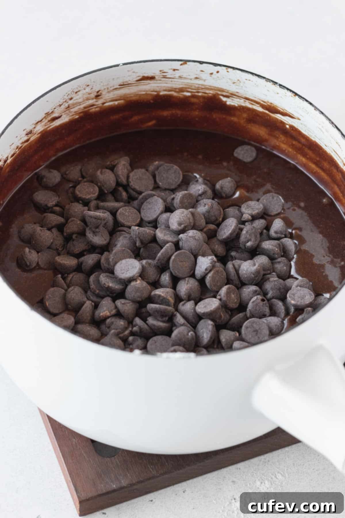 Chocolate chips getting folded into brownie batter.